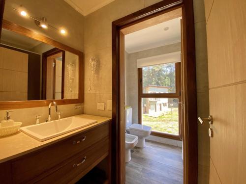 La salle de bains est pourvue d'un lavabo, de toilettes et d'un miroir. dans l'établissement Altos del Bonito, à Villa La Angostura