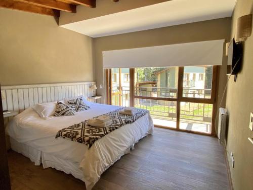 1 dormitorio con 1 cama y balcón en Altos del Bonito, en Villa La Angostura