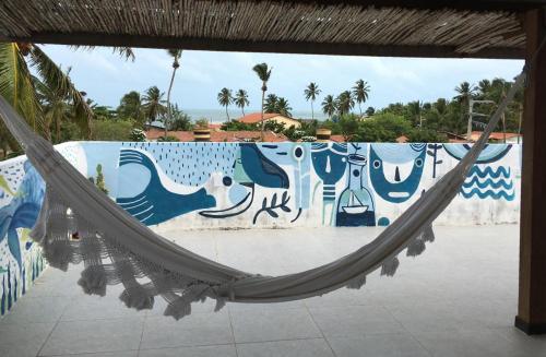 amaca di fronte a un muro con un murale di CASA PIPA BG a Barra Grande