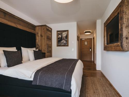 a bedroom with a large bed with a black headboard at VAYA Fieberbrunn inklusive Gästekarte in Fieberbrunn