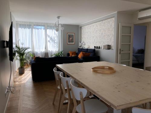 a kitchen and living room with a table and a couch at La Maison, 4 appartements 3 étoiles climatisés au centre ville avec jardin proche du Parc et des Thermes in Lons-le-Saunier