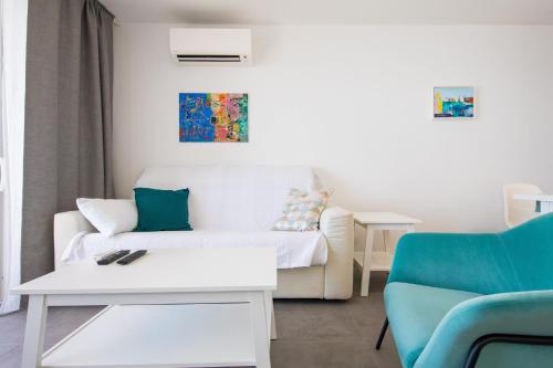 een woonkamer met een witte bank en een blauwe stoel bij Studio 87 in Dubrovnik