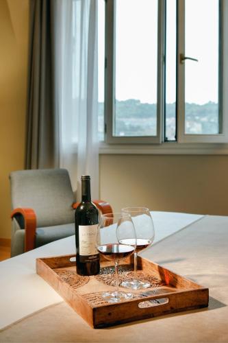 a bottle of wine and two glasses on a table at Abba Euskalduna Hotel in Bilbao