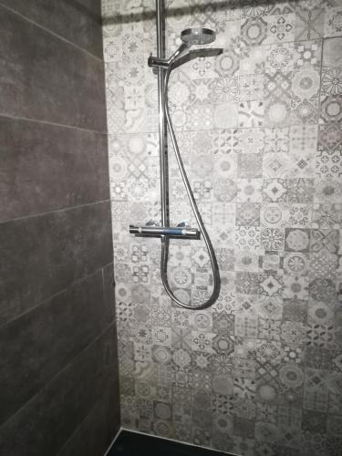 une douche dans une salle de bain avec un sol carrelé dans l'établissement Mas d'Antan, à Saint-Paul-les-Fonts