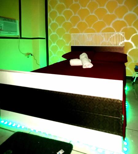 a bedroom with a bed with red and white at Cabanatuan City PNY Transient INN 2 in Cabanatuan