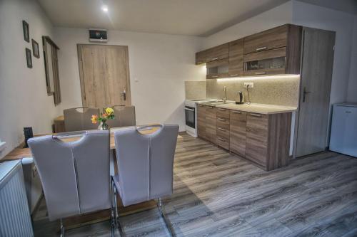a kitchen with a table and some chairs in it at BIKE apartments 3 in Hodruša