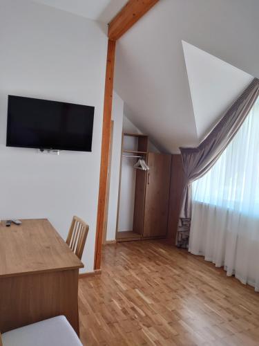 een woonkamer met een flatscreen-tv aan de muur bij Motelis Smagratis Kretinga in Kretinga