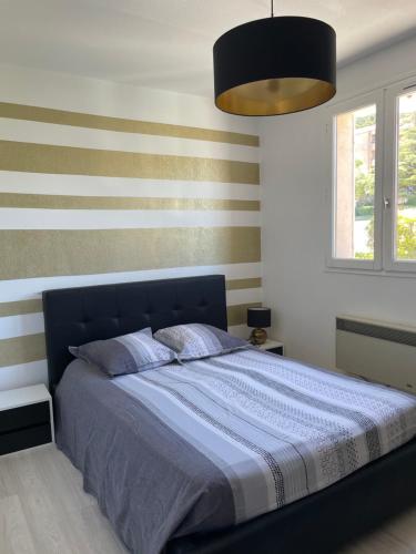 - une chambre avec un lit bleu aux murs rayés dans l'établissement T2 Proche Plage, à Carqueiranne