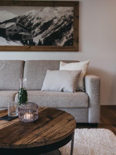 a living room with a couch and a wooden table at VAYA Fieberbrunn inklusive Gästekarte in Fieberbrunn