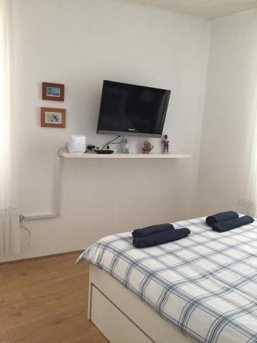 a bedroom with a bed and a flat screen tv at Holiday Home Isabella in Vis