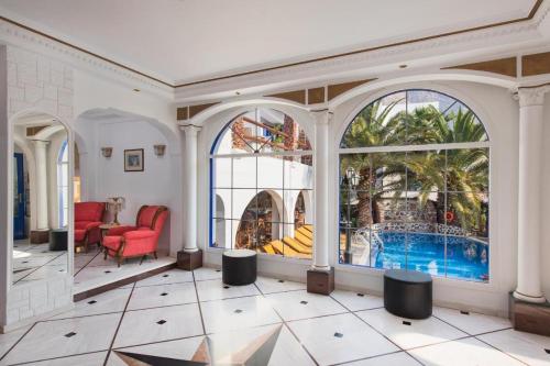 a living room with a swimming pool in a building at Black Sandy Beach in Perissa