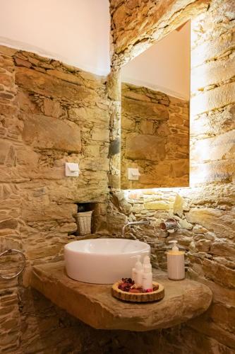 a bathroom with a sink in a stone wall at Casas de Campo do Castro da Cola in Marchicão