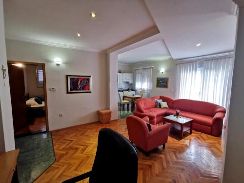 a living room with a red couch and a table at Hotel Soldo in Međugorje