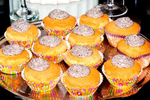 a bunch of cupcakes sitting on a glass tray at Black Sandy Beach in Perissa