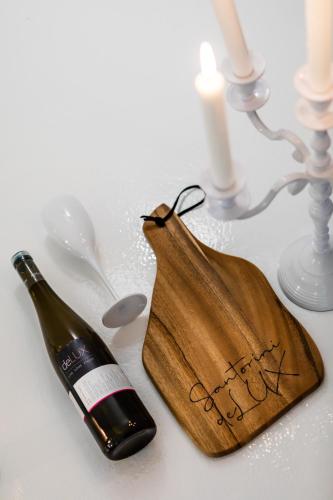 a bottle of wine and a bag on a table at Santorini Delux in Imerovigli