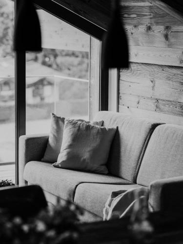 a couch in a living room with a window at VAYA Fieberbrunn inklusive Gästekarte in Fieberbrunn
