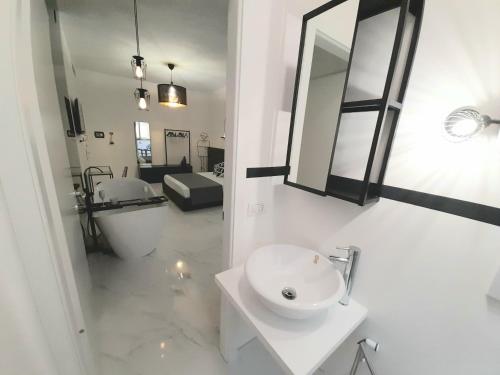 uma casa de banho branca com um lavatório e um espelho em B&B Secret Suite em Gallipoli