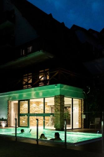 a house with a swimming pool at night at Hotel Termál in Vyhne