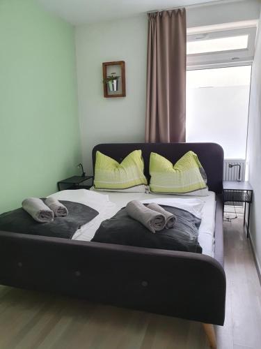 uma cama com duas almofadas e uma janela num quarto em Kaktusz City em Hévíz