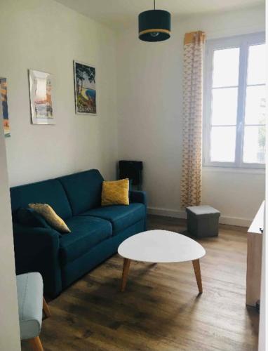a living room with a blue couch and a white table at Bright Apartment In The Center Of La Baule in La Baule