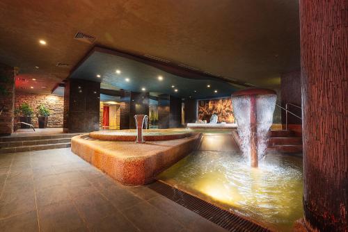 a lobby with a fountain in the middle of a room at Hotel Termál in Vyhne