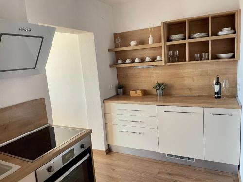 una cocina con armarios blancos y fregadero en Apartment Araucaria, en Crikvenica