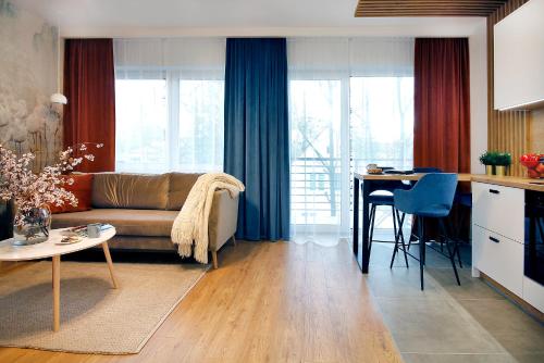- un salon avec un canapé et une table dans l'établissement W&K Apartments - Harmony Suite, à Koszalin