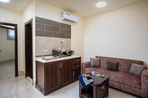 uma sala de estar com um sofá e uma mesa em Al Riyati Hotel Apartments em Aqaba