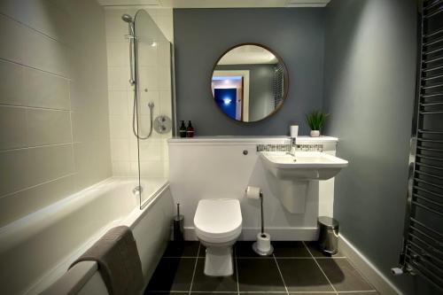 a bathroom with a toilet and a sink and a mirror at Middlehaven Apartment in Middlesbrough