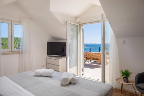 a bedroom with a bed and a view of the ocean at WATERFRONT SEA DREAM VILLA in Milna