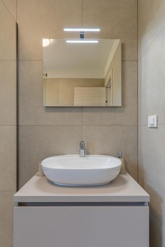 a white sink in a bathroom with a mirror at Villa Orhideja in Cres