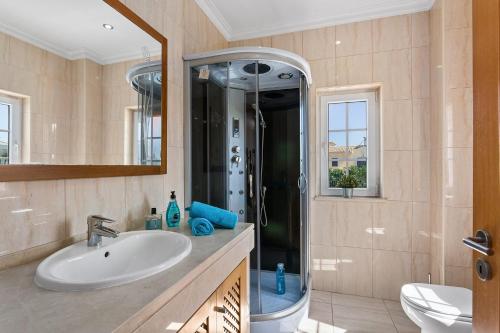 uma casa de banho com um lavatório e um chuveiro em Villa Carvalho by Villa Plus em Albufeira