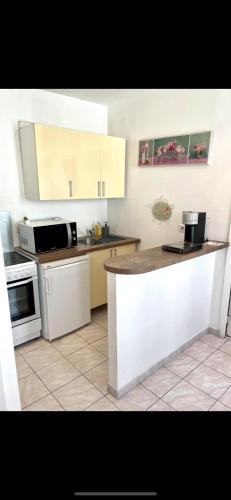 une cuisine avec des armoires blanches et un comptoir dans l'établissement Bel Appartement - HYPER CENTRE - 2 pièces, à Cannes