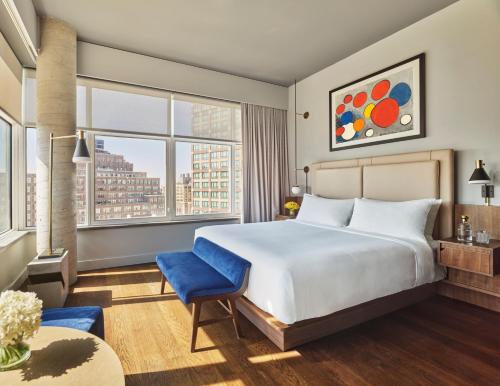 ein Schlafzimmer mit einem großen Bett und einem großen Fenster in der Unterkunft ModernHaus SoHo in New York