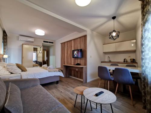 a living room with a bed a couch and a kitchen at Hotel Soldo in Međugorje