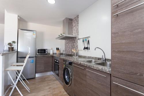 eine Küche mit Spüle und Geschirrspüler in der Unterkunft APARTAMENTO VIRGEN DEL CARMEN in Chipiona