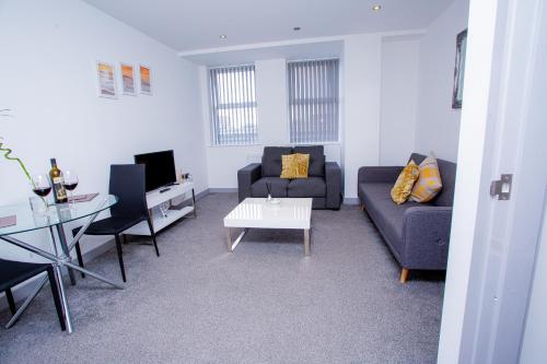 a living room with a couch and a table at Cosy Executive City Apartment in Doncaster