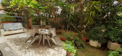 une terrasse avec une table, des chaises et des plantes dans l'établissement L'Angoletto, à Ciampino