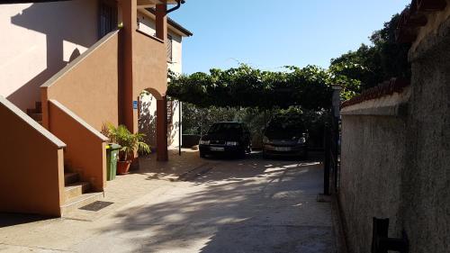twee auto's geparkeerd in een straat naast een gebouw bij Apartments Iva in Pula