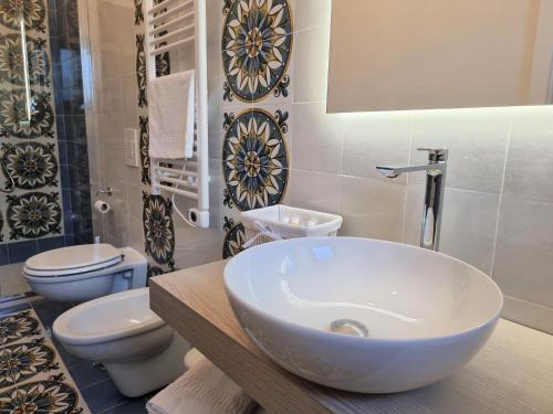 a bathroom with a white sink and two toilets at Casa Fifina Rooms in Sant'Egidio del Monte Albino