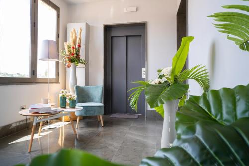 a living room with a table and chairs and plants at Enny Camere in Alcamo