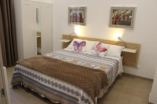 ein Schlafzimmer mit einem Bett mit Schmetterlingen auf den Kissen in der Unterkunft L'Angoletto#1 in Ciampino