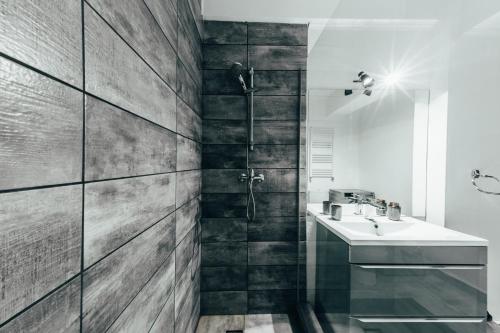 オラデアにあるUrban Stay Apartmentのシャワーと洗面台付きのバスルーム