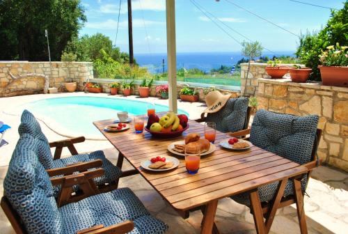 a wooden table with fruit on it next to a pool at Loggos Seaview Cottage with Pool by Konnect in Longós