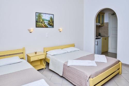 a room with two beds and a kitchen at Sunshine in Naxos Chora