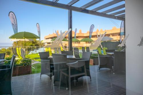 a patio with tables and chairs and a view of the ocean at Albatros Family in Salou