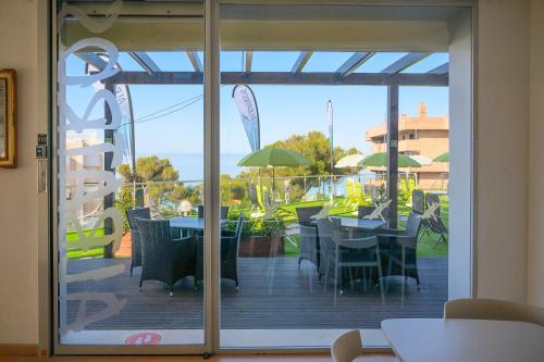 an open door to a patio with tables and umbrellas at Albatros Family in Salou