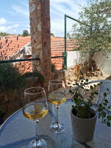 dois copos de vinho branco sentados numa mesa em Apartments Lošotovi Vrboska em Vrboska