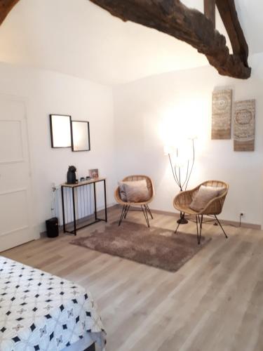 a bedroom with two chairs and a table at Domaine de Merugat Chambre d'Hôtes in Valeilles