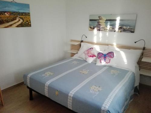 um quarto com uma cama com borboletas nas almofadas em L'Angoletto#2 em Ciampino
